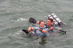 BIDEFORD, DEVON, ENGLAND - JULY 24 2022: Participants in annual Water Festival Cardboard Boat Race, River Torridge. Rainy day.